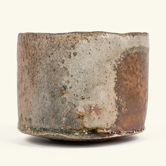 A handmade ceramic bowl with a rustic, hand-painted glaze featuring mottled brown, gray, and beige tones, photographed against a plain off-white background.