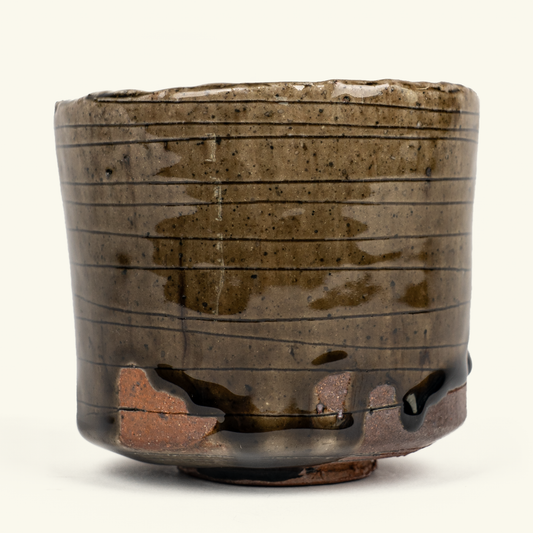 A handmade ceramic bowl with a rustic, hand-painted glaze in earthy brown and olive tones, featuring horizontal dark lines and dripping glaze details, set against a plain off-white background.